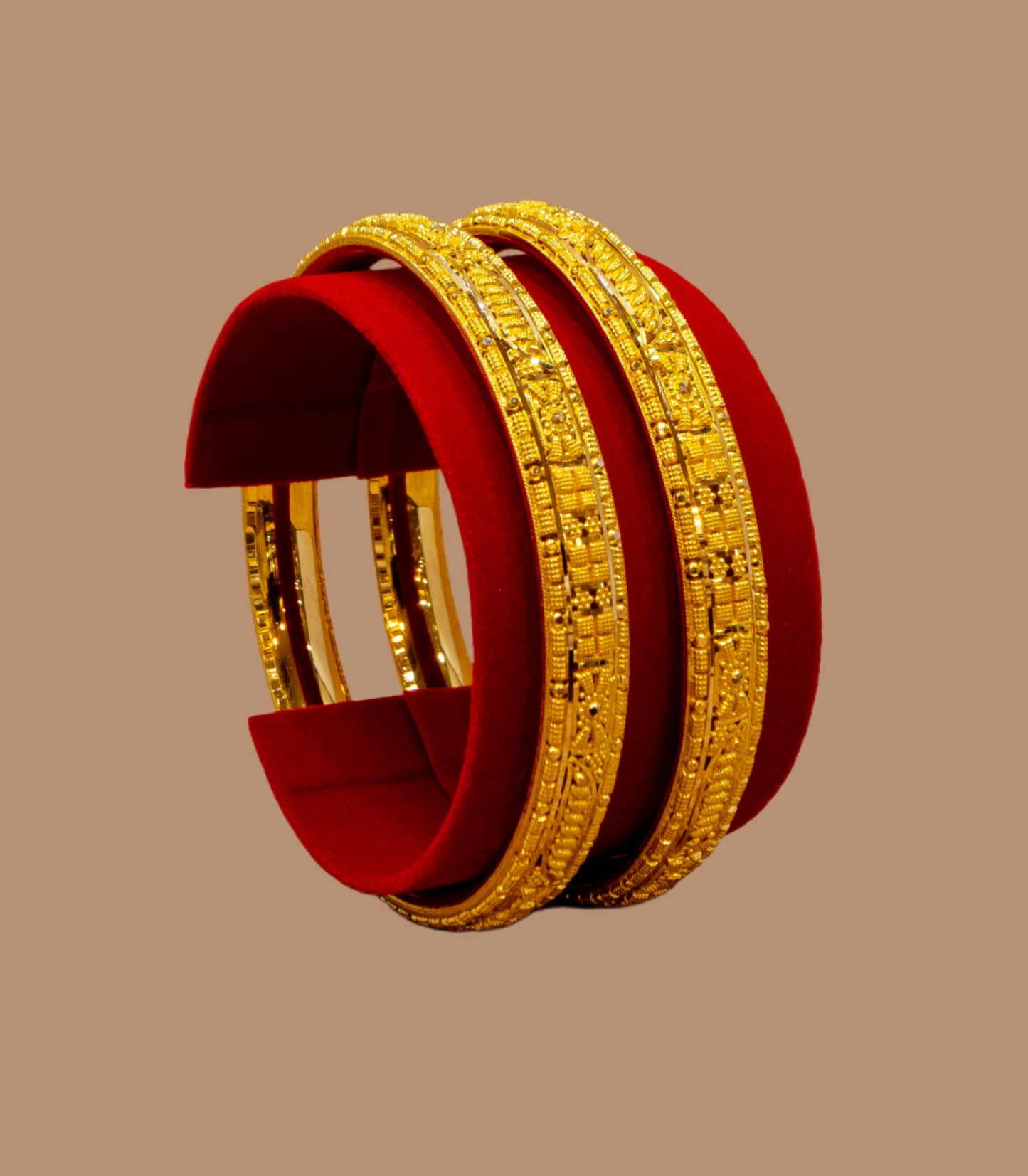 Gold bangles on a red stand against a beige background