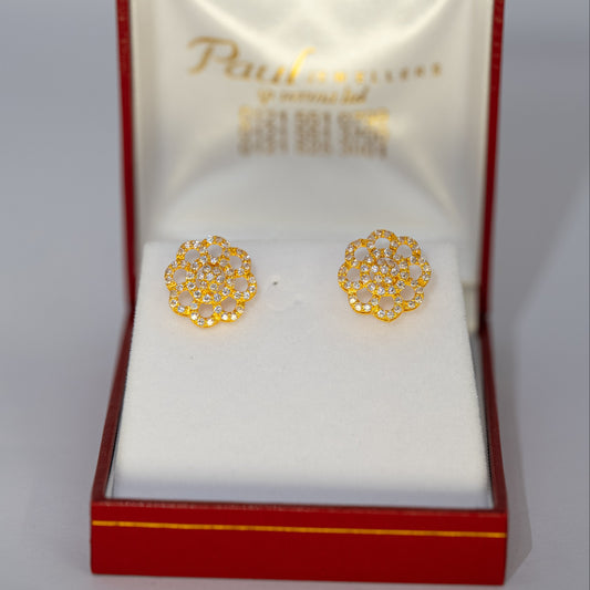Gold earrings in a red and gold box on a white background