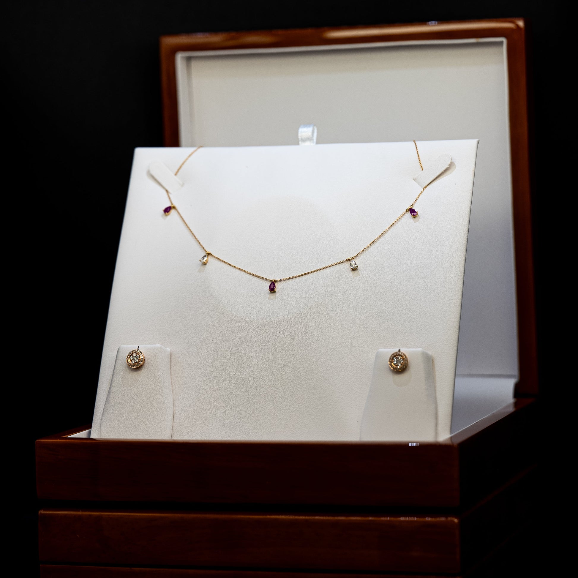Necklace displayed on a stand with a white card in a wooden box