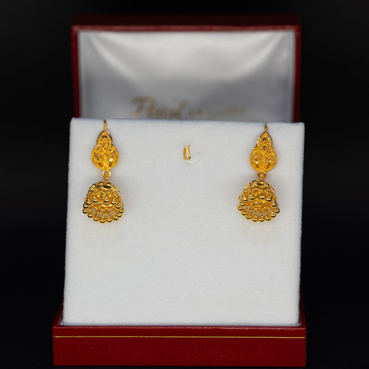 Gold earrings displayed in a jewelry box on a black background