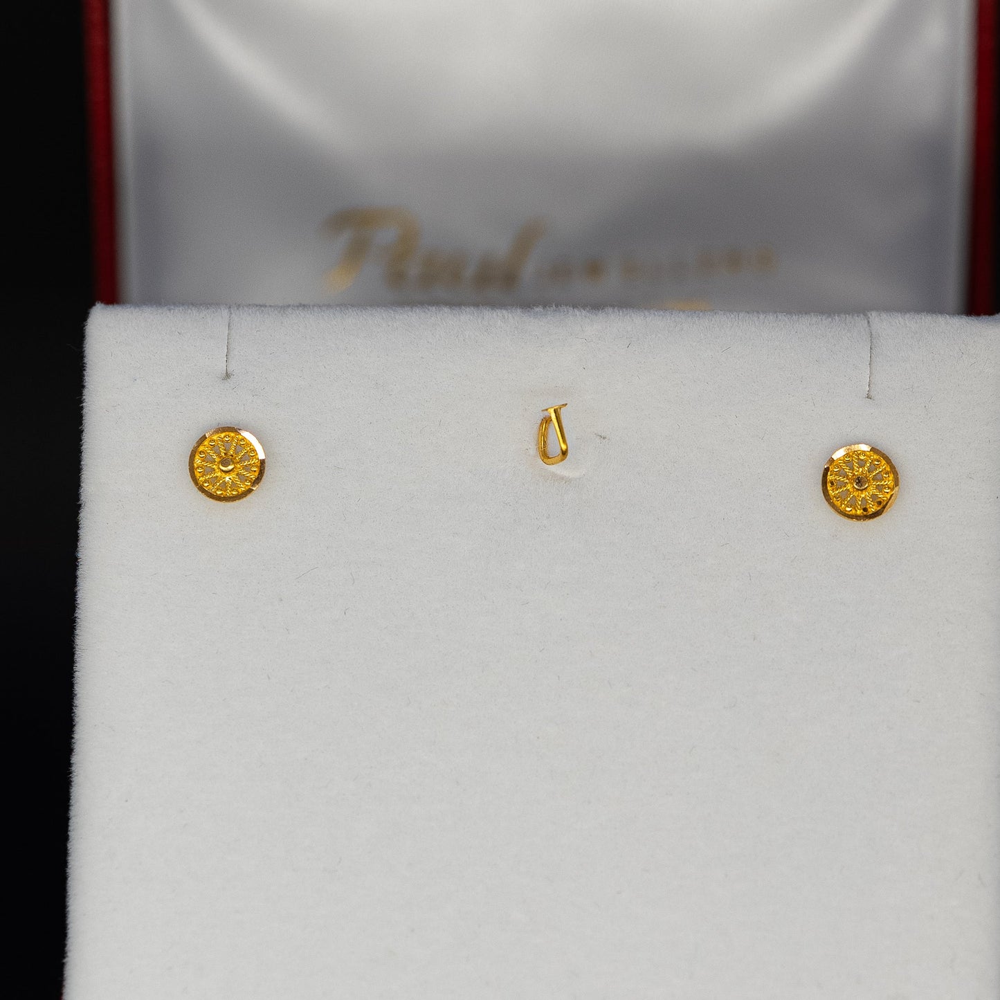 Gold earrings in box on a black background