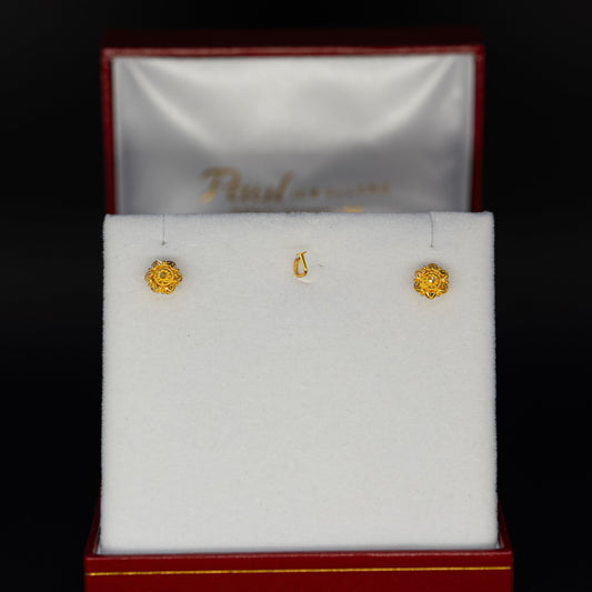 Gold earrings in a jewelry box with a dark background