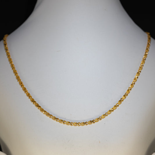Gold necklace on a mannequin with a plain background