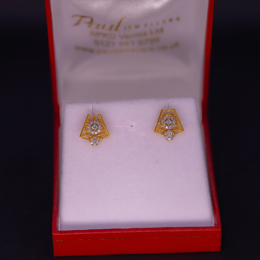 Gold earrings with diamond accents in a red box labeled 'Paul'.