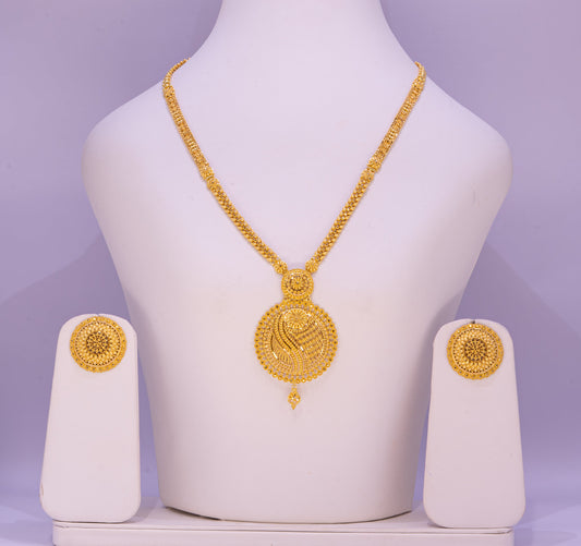 Gold necklace and earrings set on a white mannequin bust with a purple background