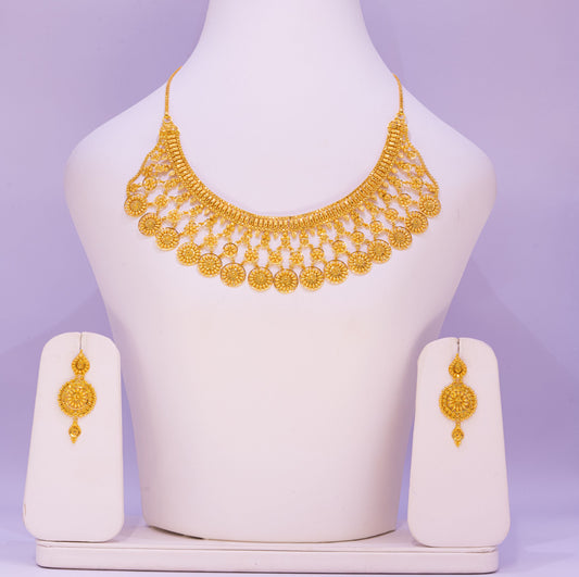 Gold necklace and earrings set on a mannequin bust with a purple background