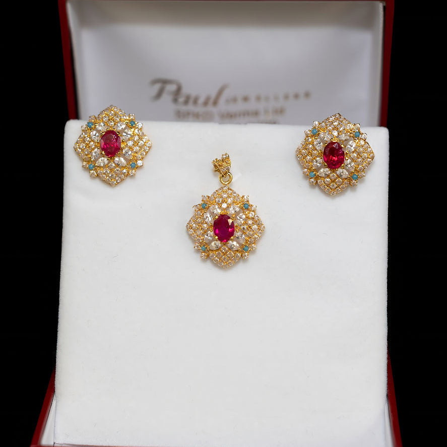 Gold earrings with red stones on a branded box