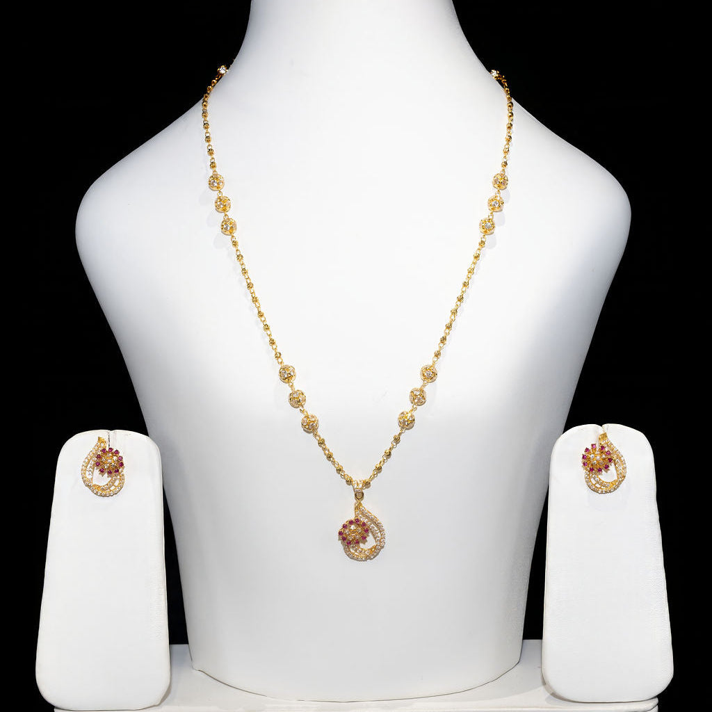 Gold necklace and earrings set on a white mannequin bust against a black background