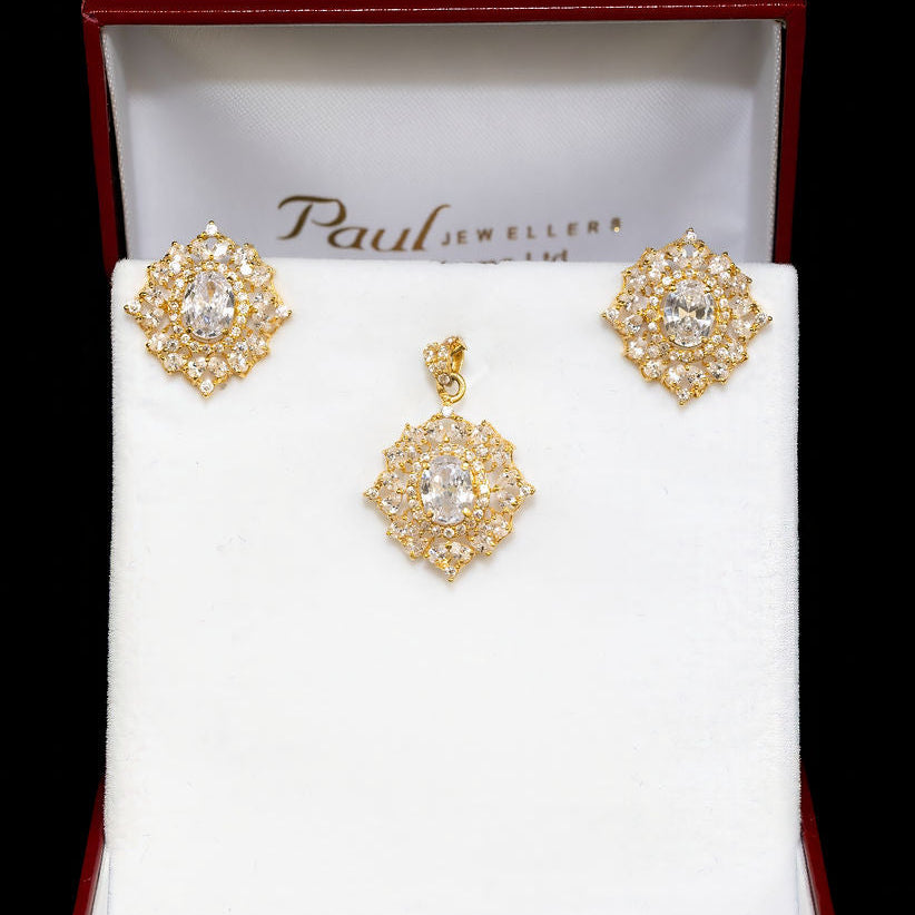 Gold earrings in a Paul Jewellers box on a white background
