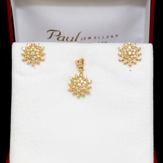 Gold earrings in a Paul Jewellers box on a black background