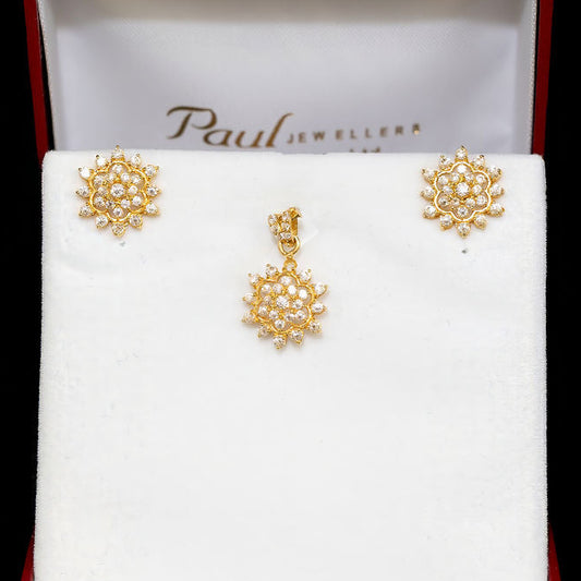 Gold earrings in a Paul Jewellers box on a black background
