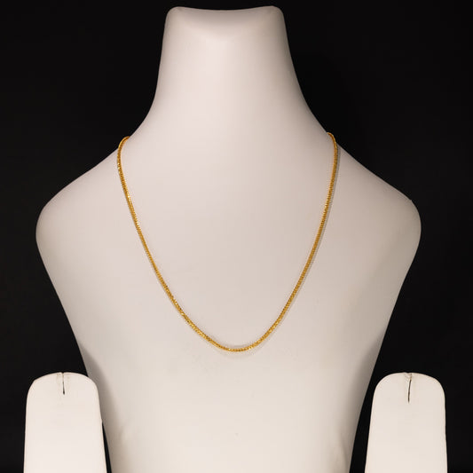 Mannequin bust with a gold necklace on a black background